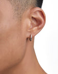 Model wearing white gold earrings by Iceman Society